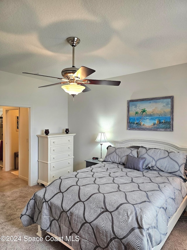 carpeted bedroom with a textured ceiling and ceiling fan