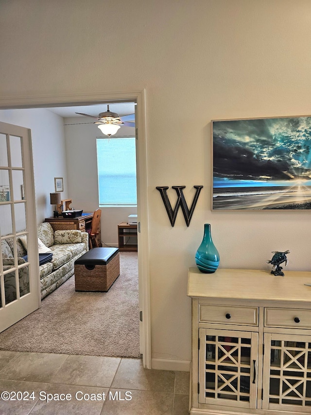 carpeted living room with ceiling fan