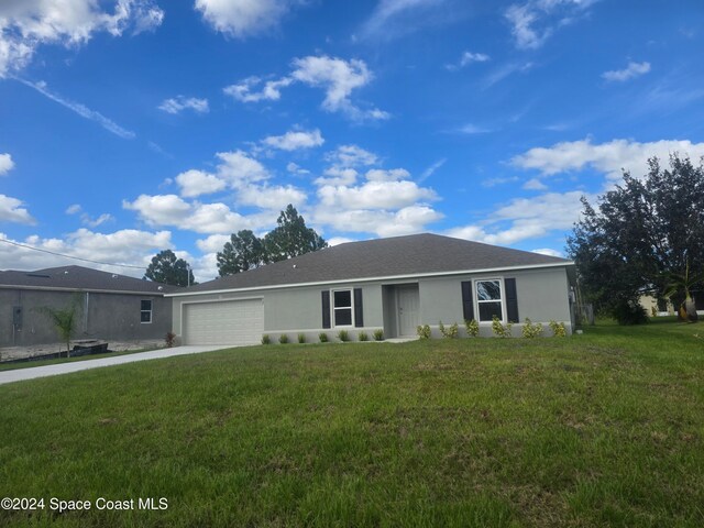 single story home featuring a garage and a front lawn