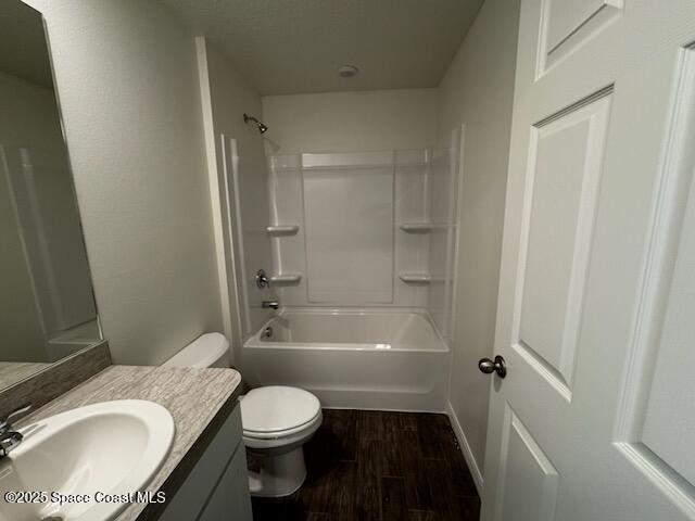 full bathroom with hardwood / wood-style flooring, vanity, toilet, and shower / washtub combination