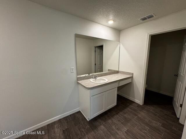 427 Fountain St SW, Palm Bay, FL 32908 - bathroom with wood finished floors, vanity, and a textured ceiling