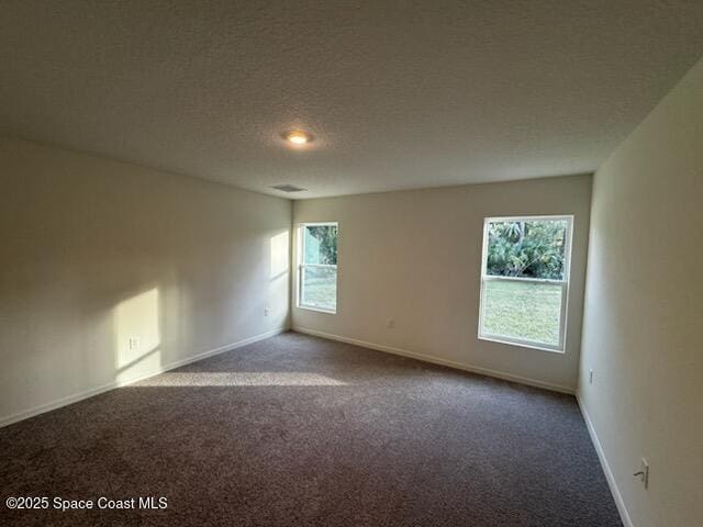 carpeted spare room with a textured ceiling