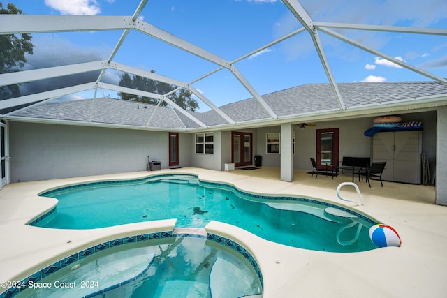 view of pool with ceiling fan, a patio, an in ground hot tub, and a lanai