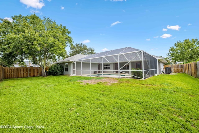 rear view of property featuring a fenced in pool, a lawn, and a lanai