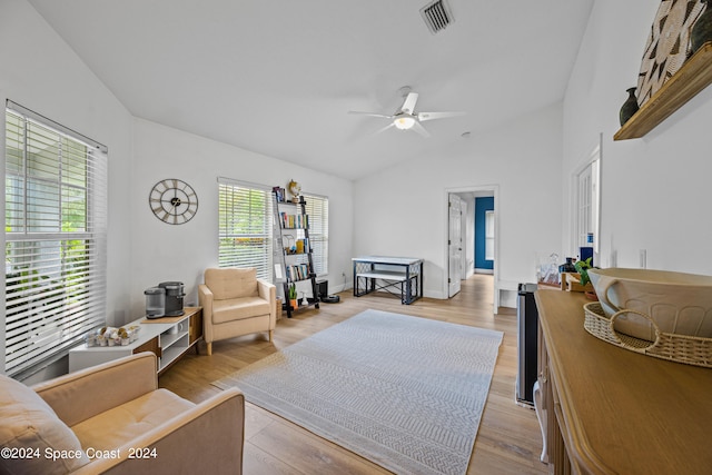 living room featuring a wealth of natural light, vaulted ceiling, ceiling fan, and light wood-type flooring