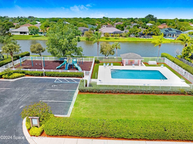 view of swimming pool featuring a patio, a water view, a playground, and a yard