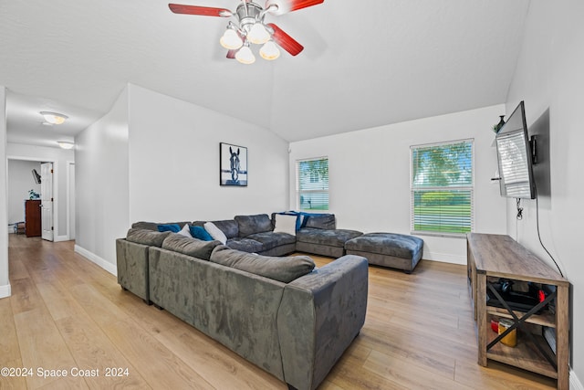 living room featuring ceiling fan, light hardwood / wood-style flooring, and vaulted ceiling