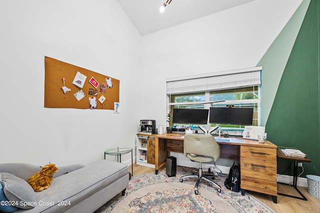 office area with high vaulted ceiling and light wood-type flooring