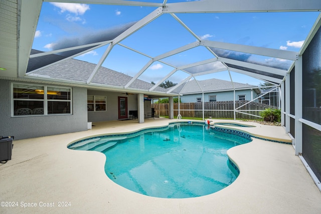 view of swimming pool with a lanai, a patio, and an in ground hot tub