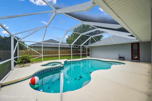 view of swimming pool with glass enclosure, an in ground hot tub, and a patio area