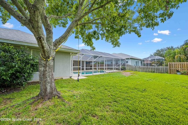 view of yard with glass enclosure and a fenced in pool