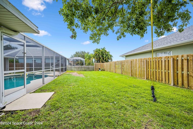 view of yard with glass enclosure and a fenced in pool