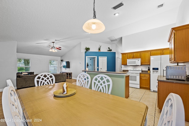 dining room featuring lofted ceiling, ceiling fan, light tile patterned floors, and a textured ceiling