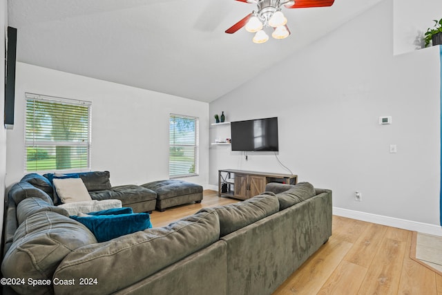 living room with light hardwood / wood-style floors, ceiling fan, and high vaulted ceiling