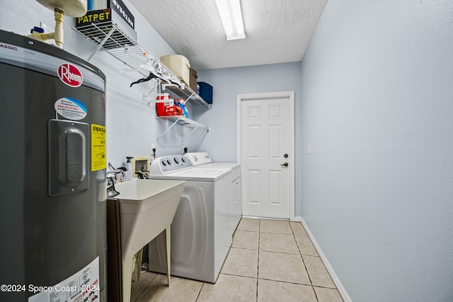 laundry room with washer and clothes dryer, water heater, a textured ceiling, and light tile patterned flooring