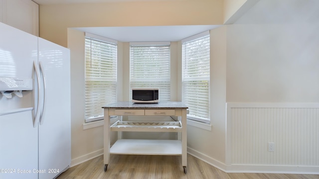 kitchen featuring light hardwood / wood-style floors and white fridge with ice dispenser