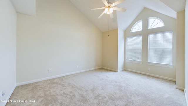 carpeted spare room featuring ceiling fan and vaulted ceiling