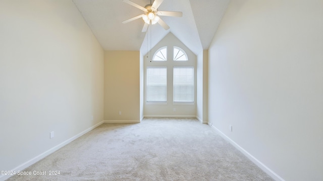 spare room featuring ceiling fan, vaulted ceiling, and light colored carpet