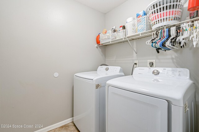 laundry area with separate washer and dryer and light tile patterned floors