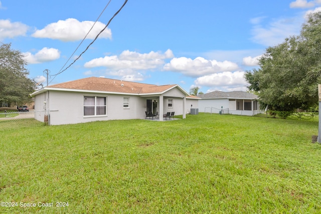 back of property with a patio and a lawn