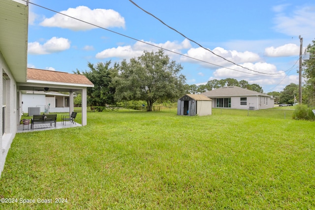 view of yard with ceiling fan, a shed, and a patio area