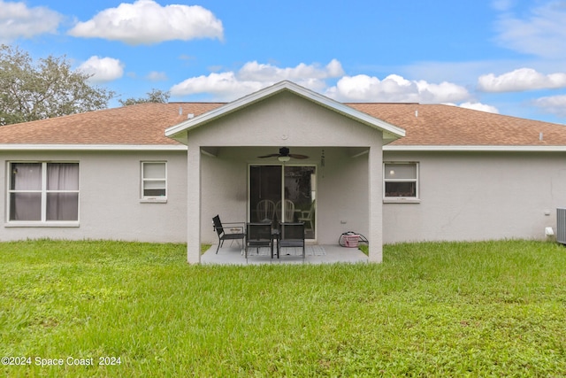 rear view of property with ceiling fan, a yard, and a patio