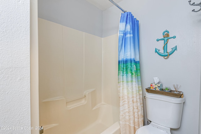 bathroom featuring shower / bath combo with shower curtain and toilet