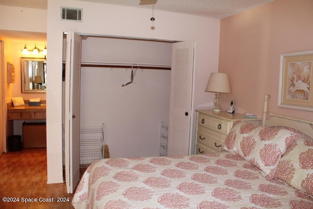 bedroom with a textured ceiling, light hardwood / wood-style flooring, and a closet