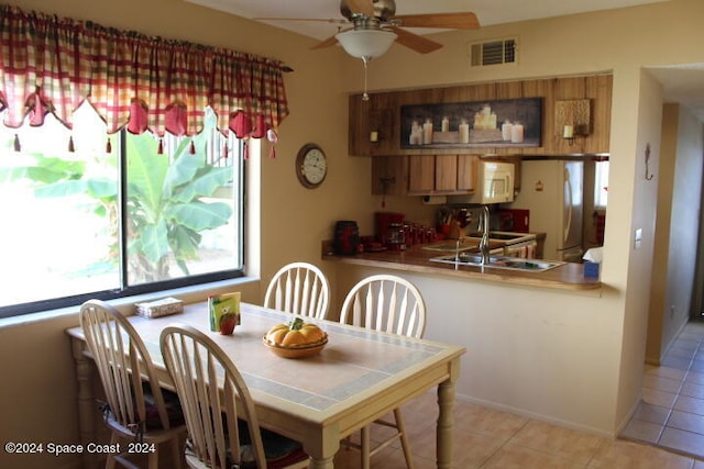 tiled dining space featuring ceiling fan