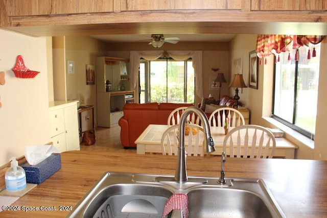 kitchen featuring beam ceiling, ceiling fan, and sink