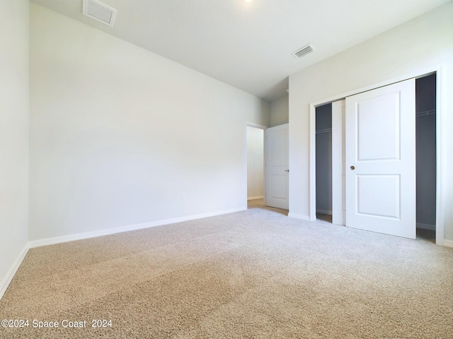 unfurnished bedroom featuring carpet and a closet