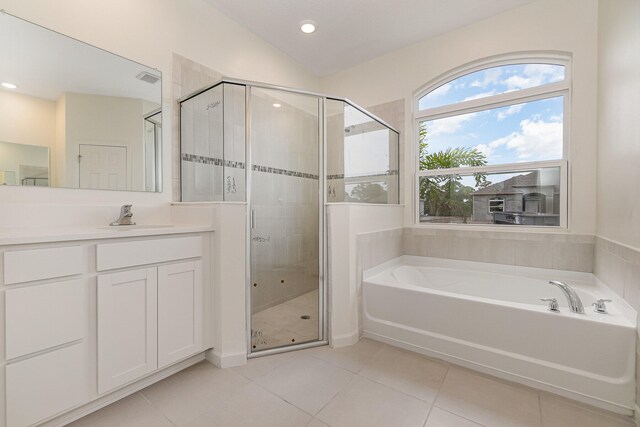 bathroom with tile patterned flooring, vanity, vaulted ceiling, and shower with separate bathtub