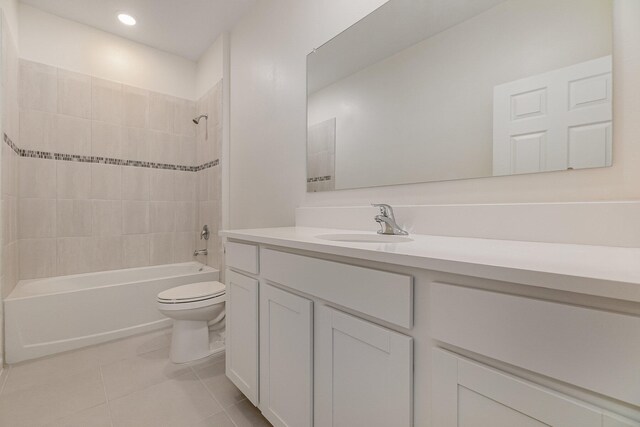 full bathroom featuring tile patterned flooring, vanity, toilet, and tiled shower / bath