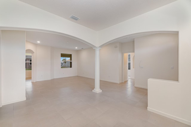 tiled empty room featuring decorative columns