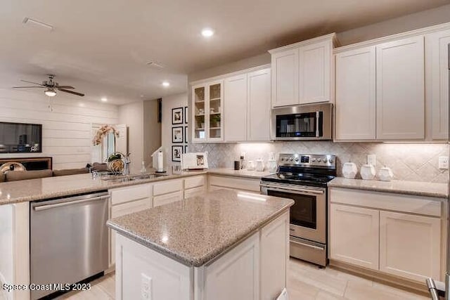 kitchen featuring light stone counters, sink, white cabinets, and appliances with stainless steel finishes