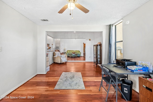 office area with ceiling fan, a textured ceiling, and hardwood / wood-style floors