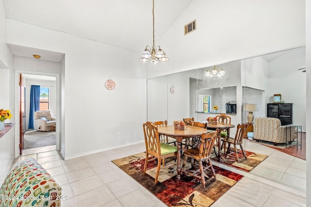 dining space with high vaulted ceiling, an inviting chandelier, and light tile patterned floors