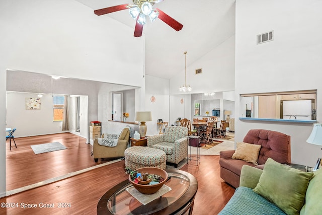 living room with light hardwood / wood-style floors, ceiling fan, and high vaulted ceiling