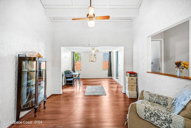 sitting room with ceiling fan, beam ceiling, and hardwood / wood-style floors