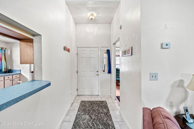 entryway featuring a textured ceiling and a towering ceiling