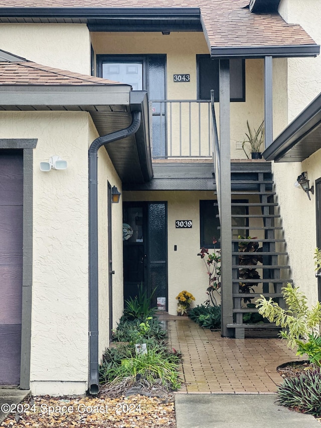 view of exterior entry with a balcony