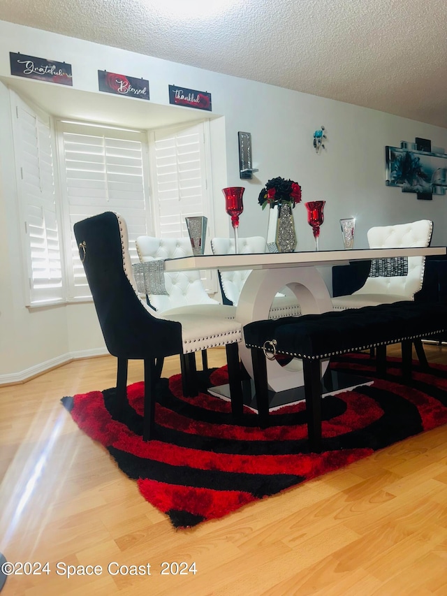 dining space featuring a textured ceiling and hardwood / wood-style floors