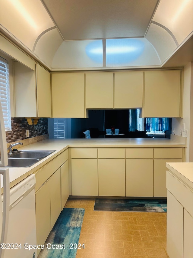 kitchen featuring backsplash, dishwasher, cream cabinetry, and sink