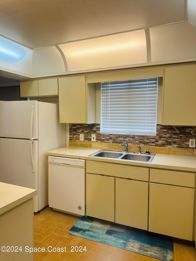 kitchen featuring cream cabinets, sink, tasteful backsplash, and white appliances