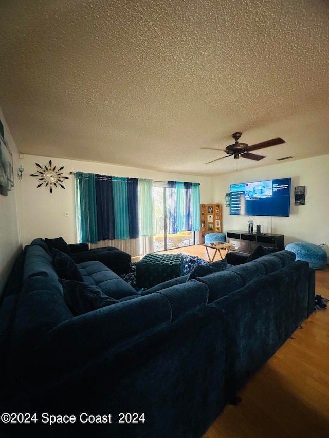 living room with wood-type flooring, a textured ceiling, and ceiling fan