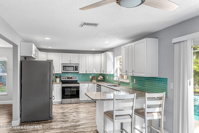 kitchen featuring light hardwood / wood-style floors, appliances with stainless steel finishes, and white cabinets