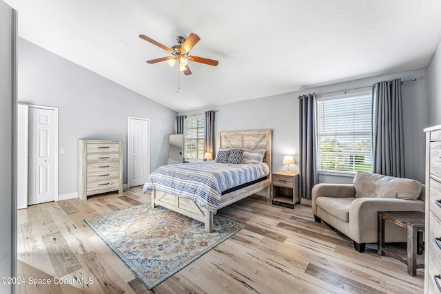 bedroom featuring ceiling fan, light wood-type flooring, and lofted ceiling