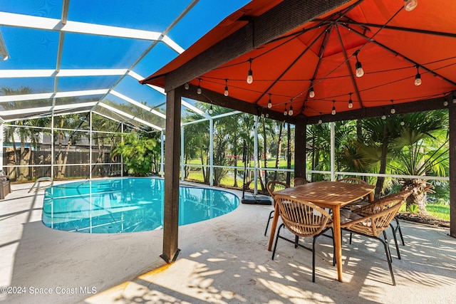 view of pool featuring glass enclosure, a patio, and a fenced in pool