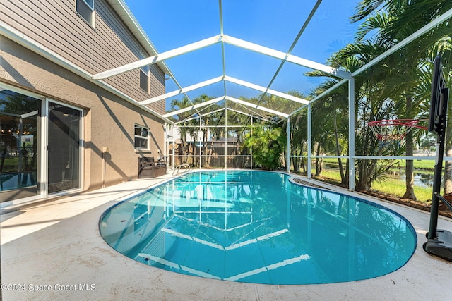 outdoor pool with glass enclosure, a patio, and fence