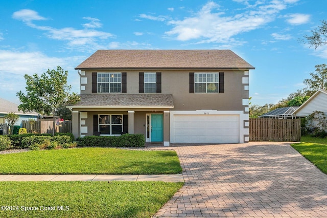 view of front of home featuring a front lawn and a garage